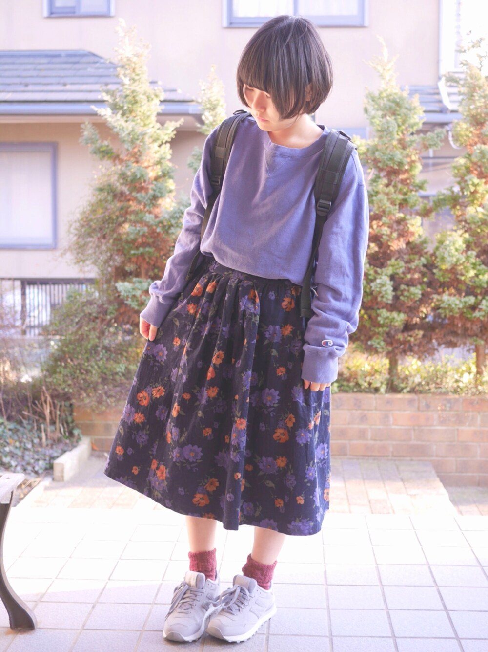 ブルー系のスウェット、ブラック系のスカート、グレー系のスニーカーを着用したレディースの春コーディネートの1枚目の写真