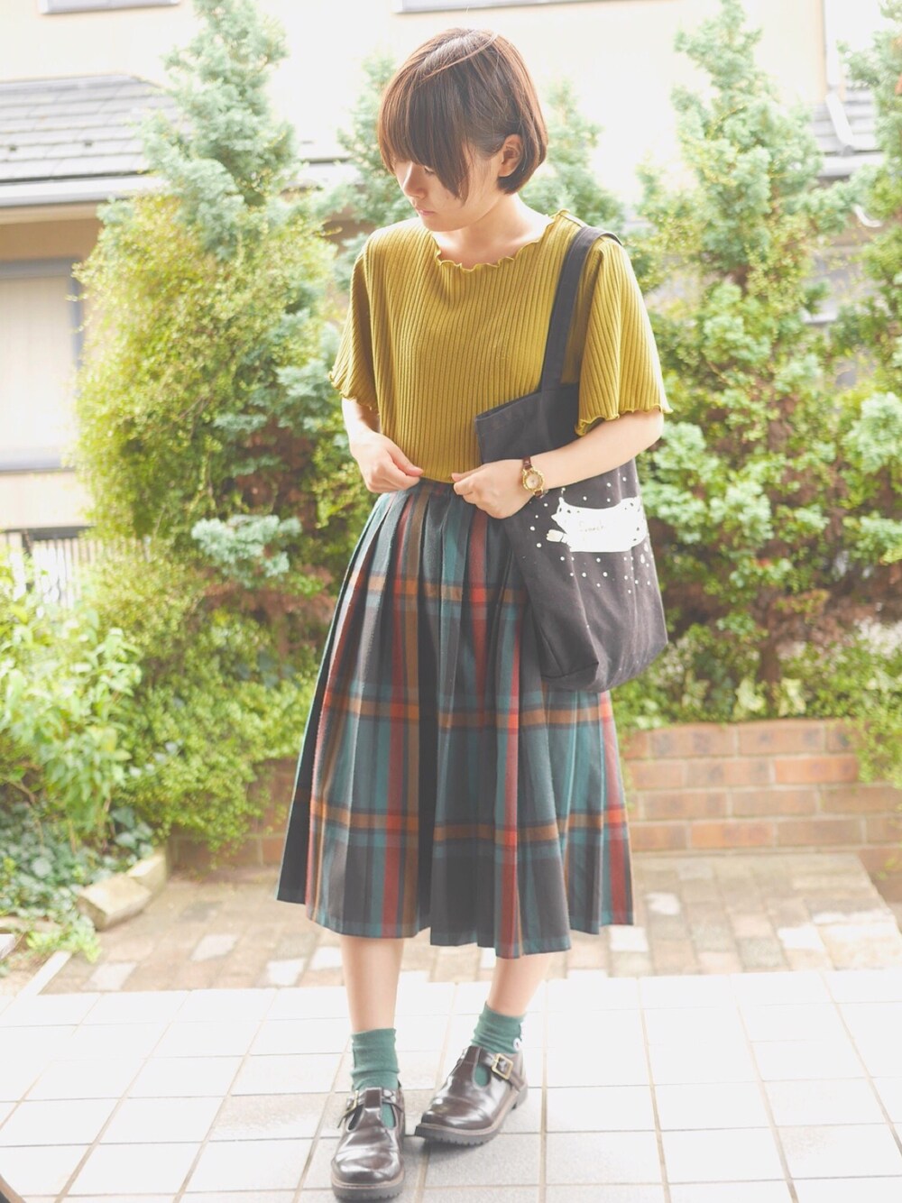 イエロー系のTシャツ/カットソー、グリーン系のスカート、ブラウン系のシューズを着用したレディースの夏コーディネートの1枚目の写真