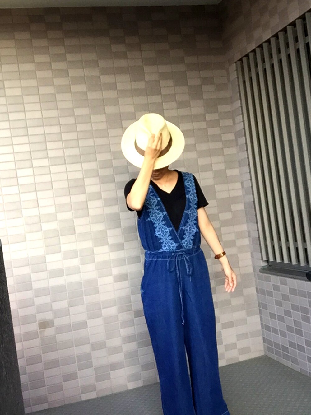 ブルー系のサロペット/オーバーオール、ブラック系のTシャツ/カットソー、ホワイト系のスニーカーを着用したレディースの秋コーディネートの1枚目の写真