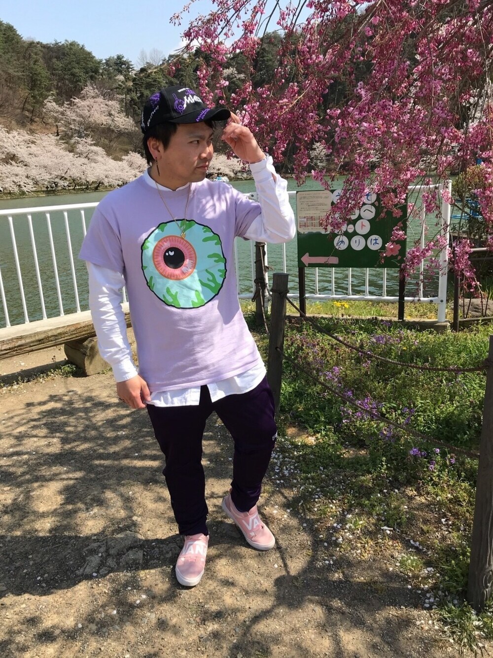 「Tシャツ、白シャツ、キャップ、スニーカー、ジャージーパンツ、ネックレス」｜「MISHKAの【MISHKA】6パネル ワッペン＆刺繍ベースボールカーブキャップ（キャップ、ブラック系）」を使った、小林一寿さん（メンズ・165cm）の春コーディネートの1枚目の写真
