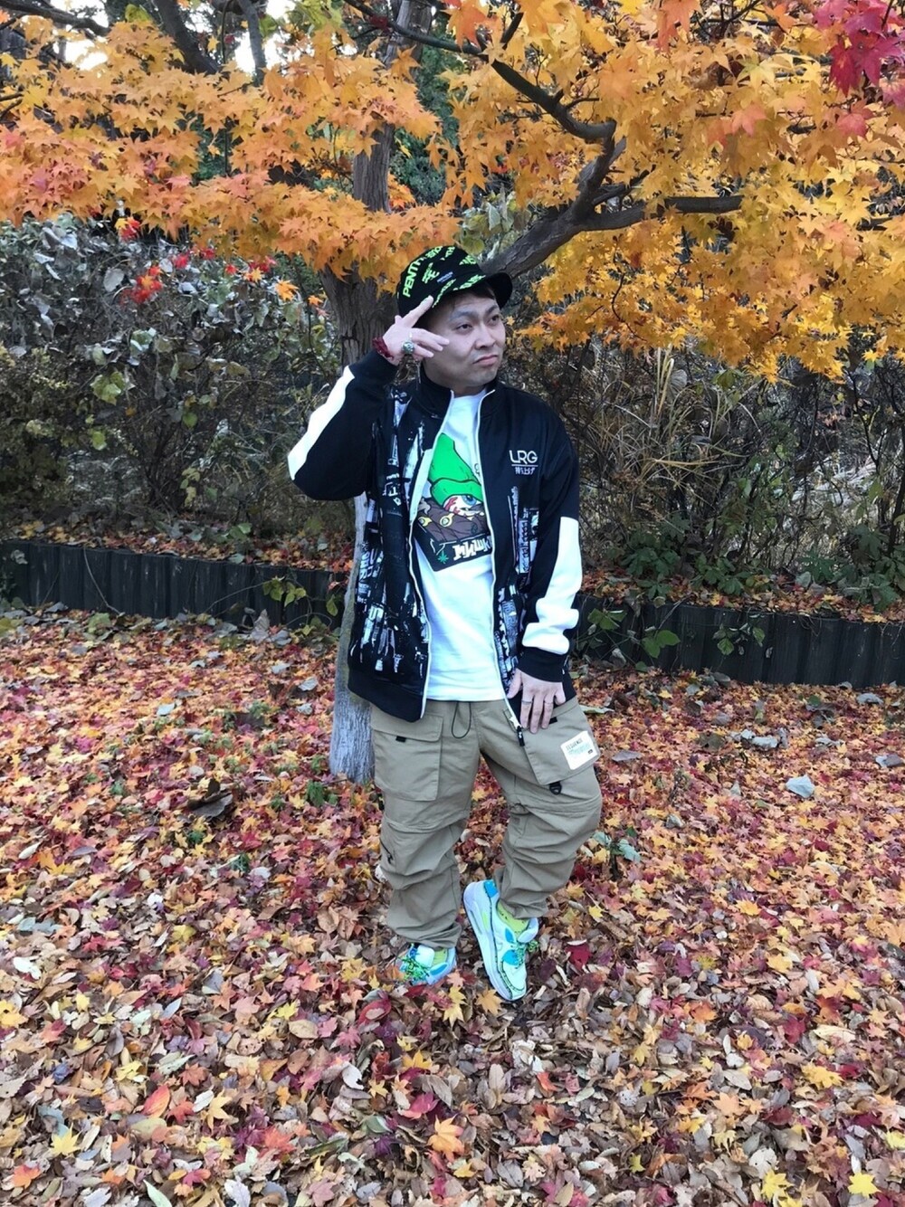 ホワイト系のTシャツ/カットソー、ブラック系のジャケット/アウター、ホワイト系のスニーカーを着用したメンズの秋コーディネートの1枚目の写真