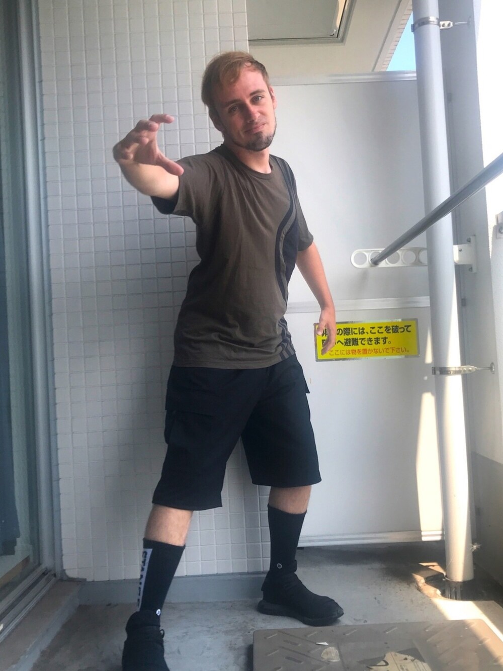 グリーン系のTシャツ/カットソー、ブラック系のその他パンツ、ブラック系のスニーカーを着用したメンズの夏コーディネートの1枚目の写真