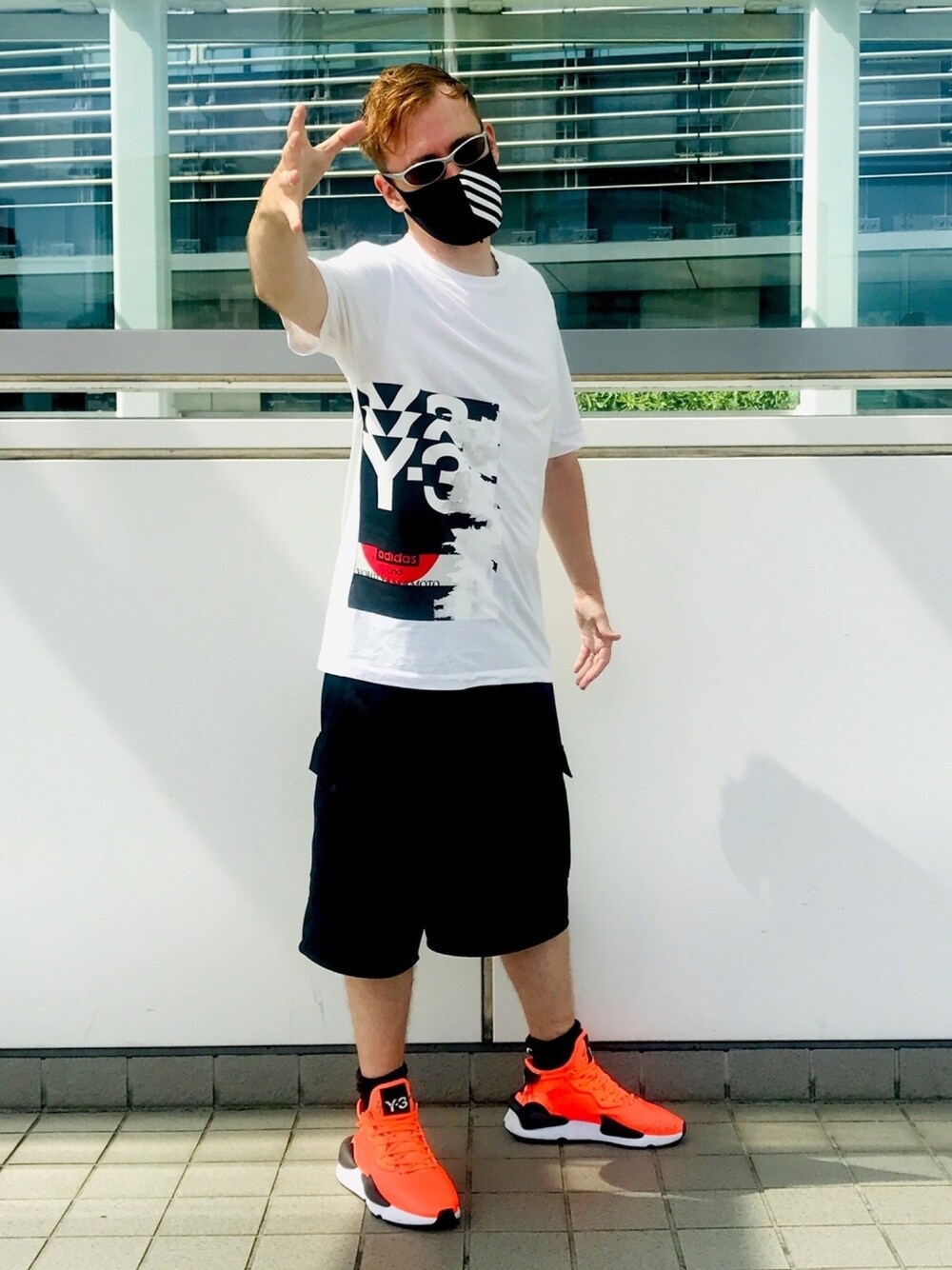 ホワイト系のTシャツ/カットソー、ブラック系のその他パンツ、オレンジ系のスニーカーを着用したメンズの秋コーディネートの1枚目の写真