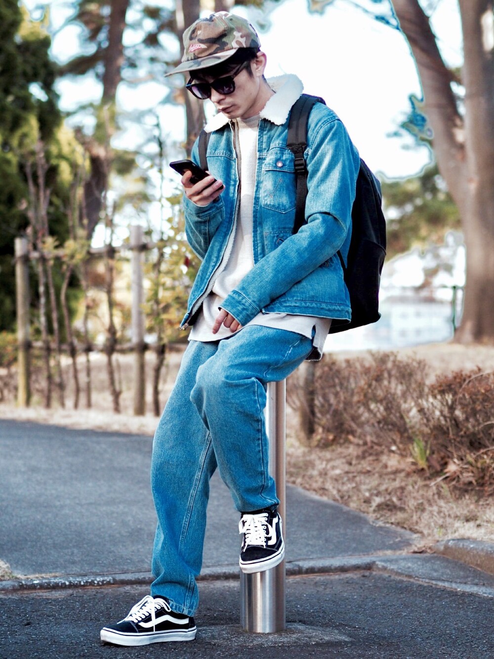 ブルー系のデニムジャケット、ベージュ系のニット/セーター、ブルー系のデニムパンツを着用したメンズの冬コーディネートの1枚目の写真