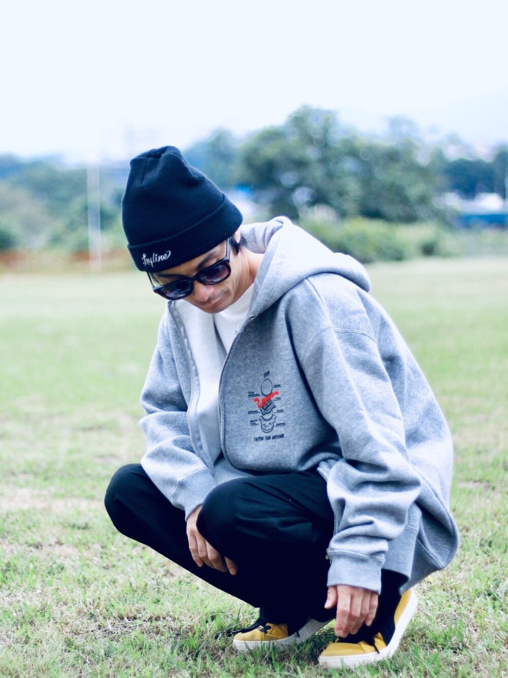 グレー系のパーカー、ホワイト系のTシャツ/カットソー、イエロー系のスニーカーを着用したメンズの秋コーディネートの1枚目の写真