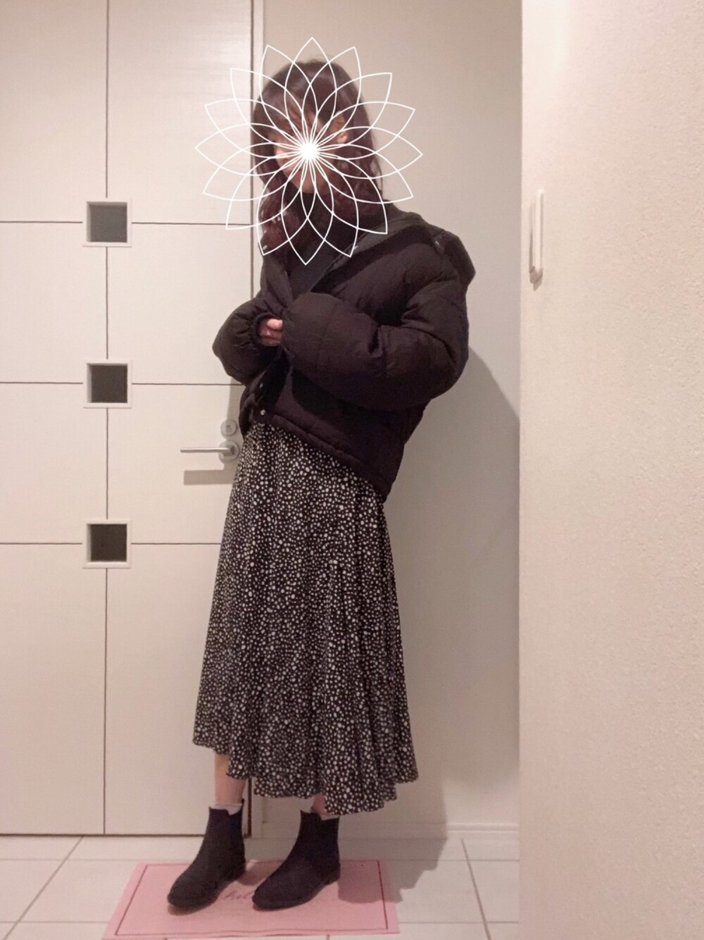 ブラック系のニット/セーター、ブラック系のダウンジャケット/コート、ブラック系のスカートを着用したレディースの冬コーディネートの1枚目の写真