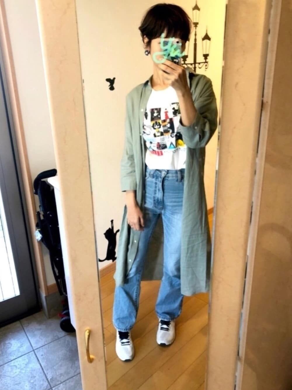 ブルー系のデニムパンツ、グリーン系のシャツワンピース、ホワイト系のTシャツ/カットソーを着用したレディースの春コーディネートの1枚目の写真