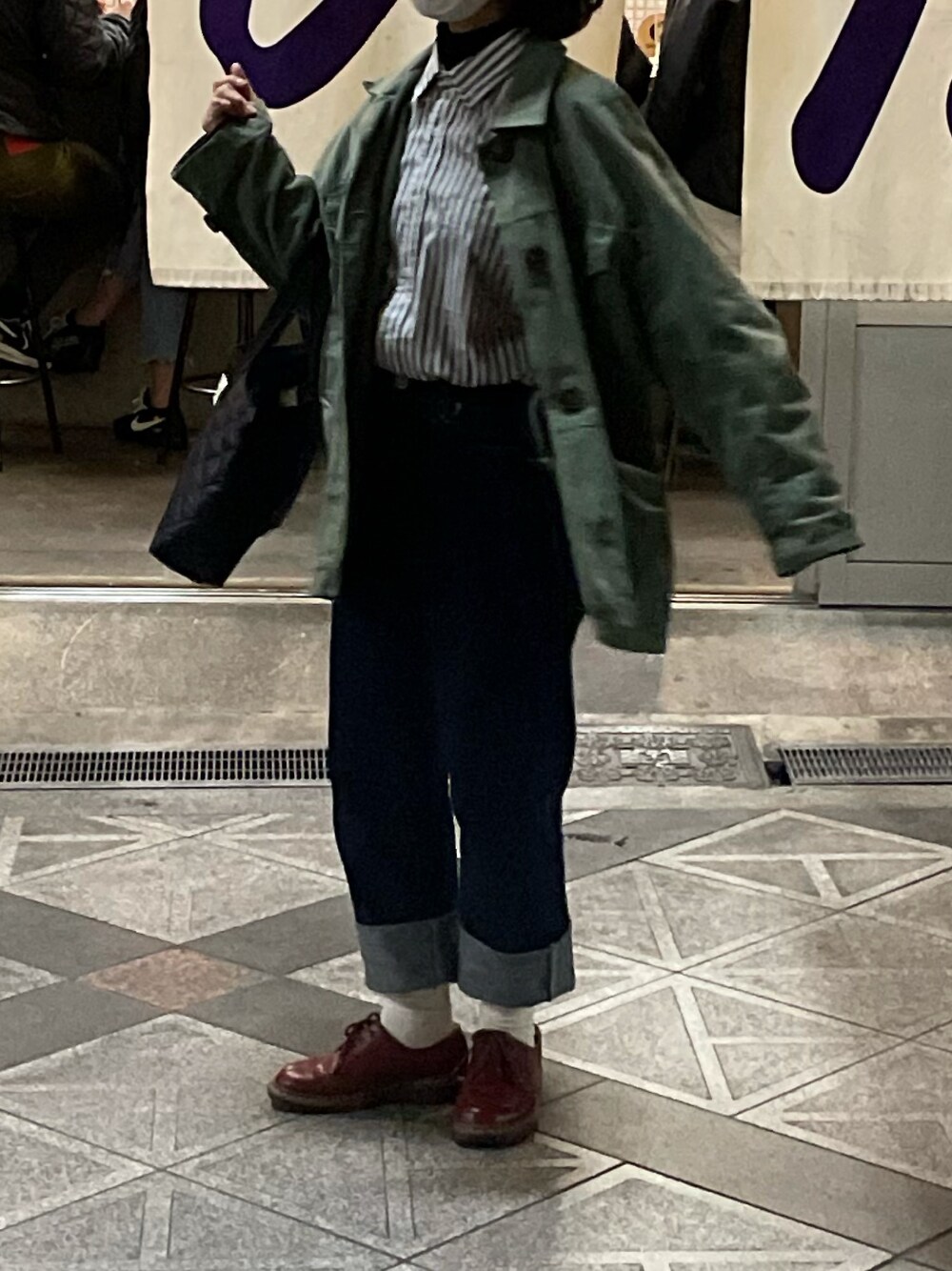 ブルー系のデニムパンツ、レッド系のドレスシューズ、ブラック系のバッグを着用したレディースの春コーディネートの1枚目の写真