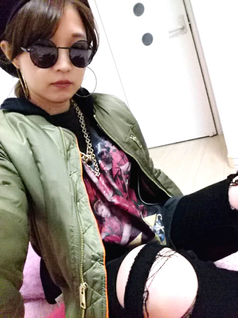 グリーン系のブルゾン、ブラック系のデニムパンツ、ゴールド系のピアス(両耳用)を着用したレディースの冬コーディネートの1枚目の写真