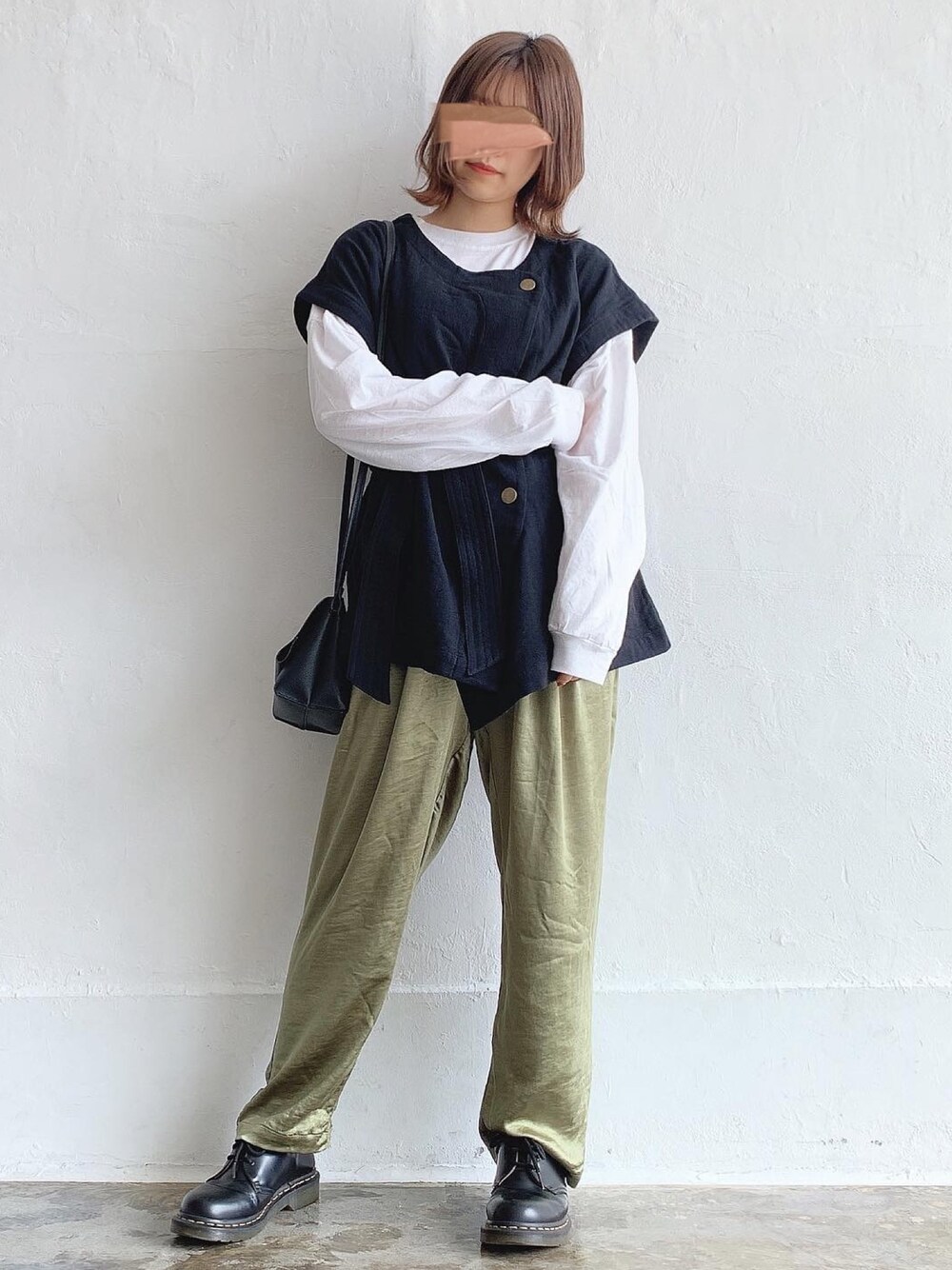 ブラック系のベスト、グリーン系のその他パンツ、ブラック系のショルダーバッグを着用したレディースの秋コーディネートの1枚目の写真