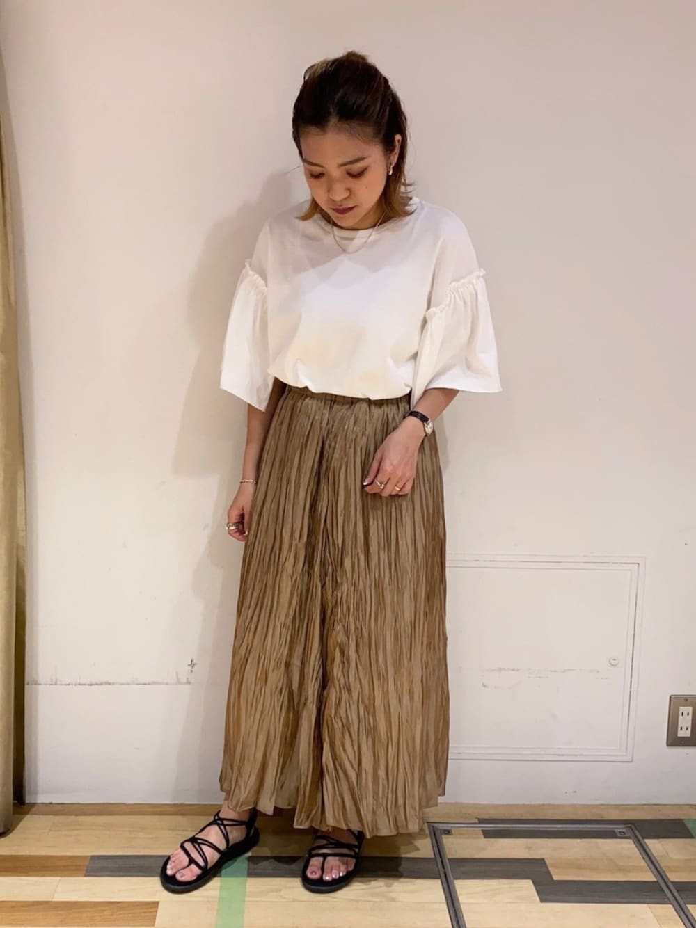 ホワイト系のTシャツ/カットソー、イエロー系のスカート、ブラック系のサンダルを着用したレディースの夏コーディネートの1枚目の写真