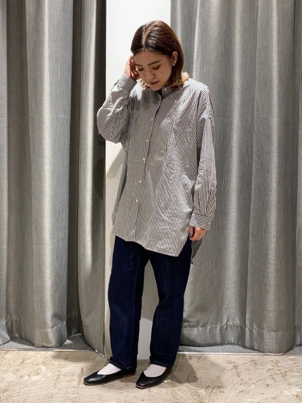 ブルー系のデニムパンツ、ブラック系のパンプスを着用したレディースの秋コーディネートの1枚目の写真