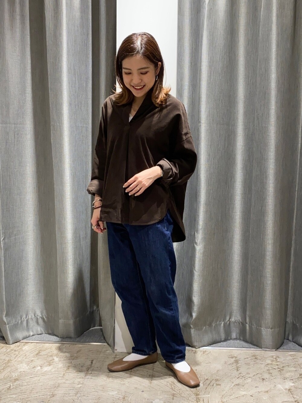 ブルー系のデニムパンツ、ブラウン系のパンプス、ブラウン系のシャツ/ブラウスを着用したレディースの秋コーディネートの1枚目の写真