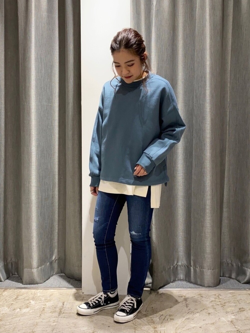 ブルー系のTシャツ/カットソー、ブルー系のデニムパンツ、ブラック系のスニーカーを着用したレディースの秋コーディネートの1枚目の写真