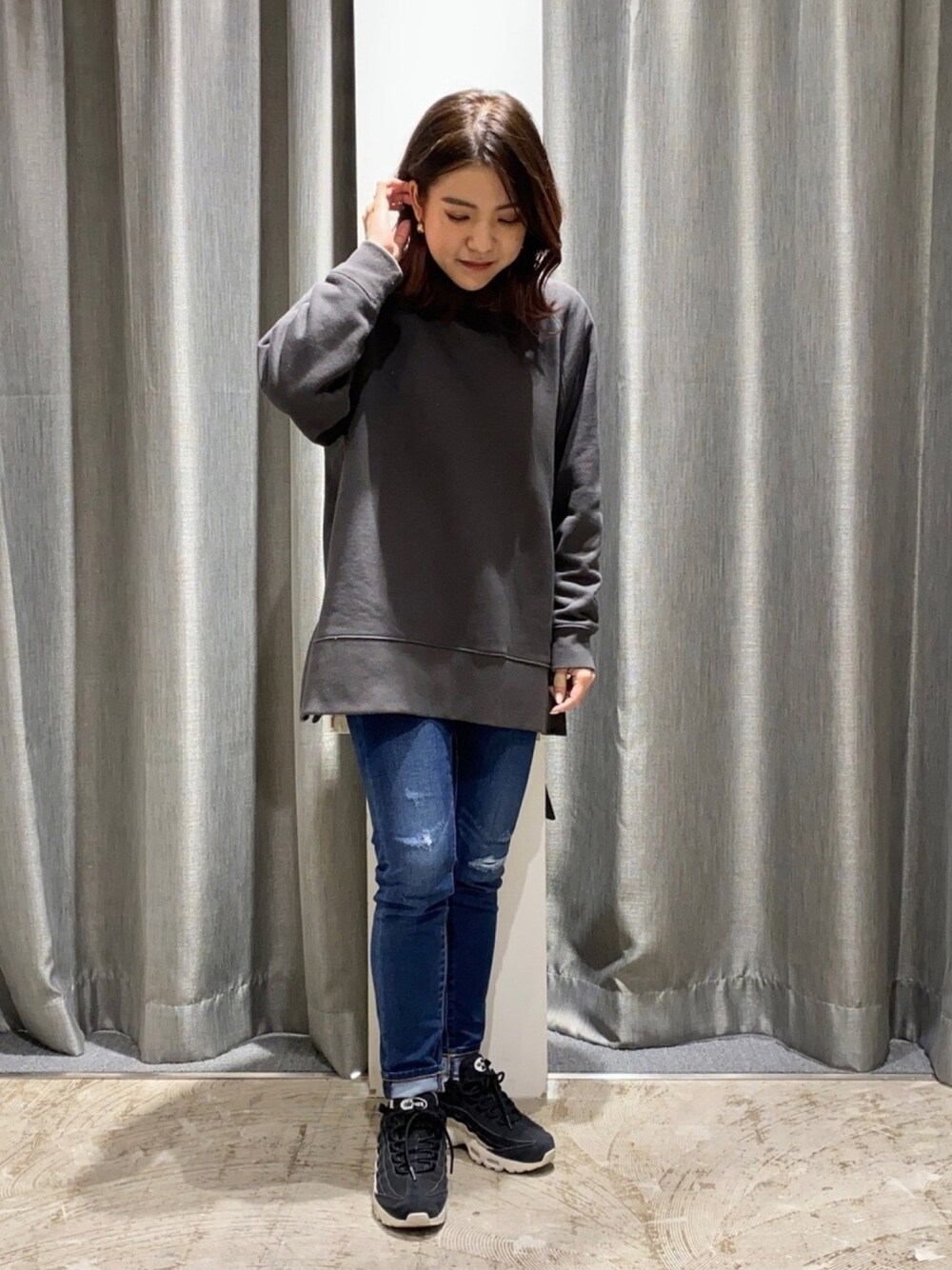 グレー系のTシャツ/カットソー、ブルー系のデニムパンツ、ブラック系のスニーカーを着用したレディースの冬コーディネートの1枚目の写真