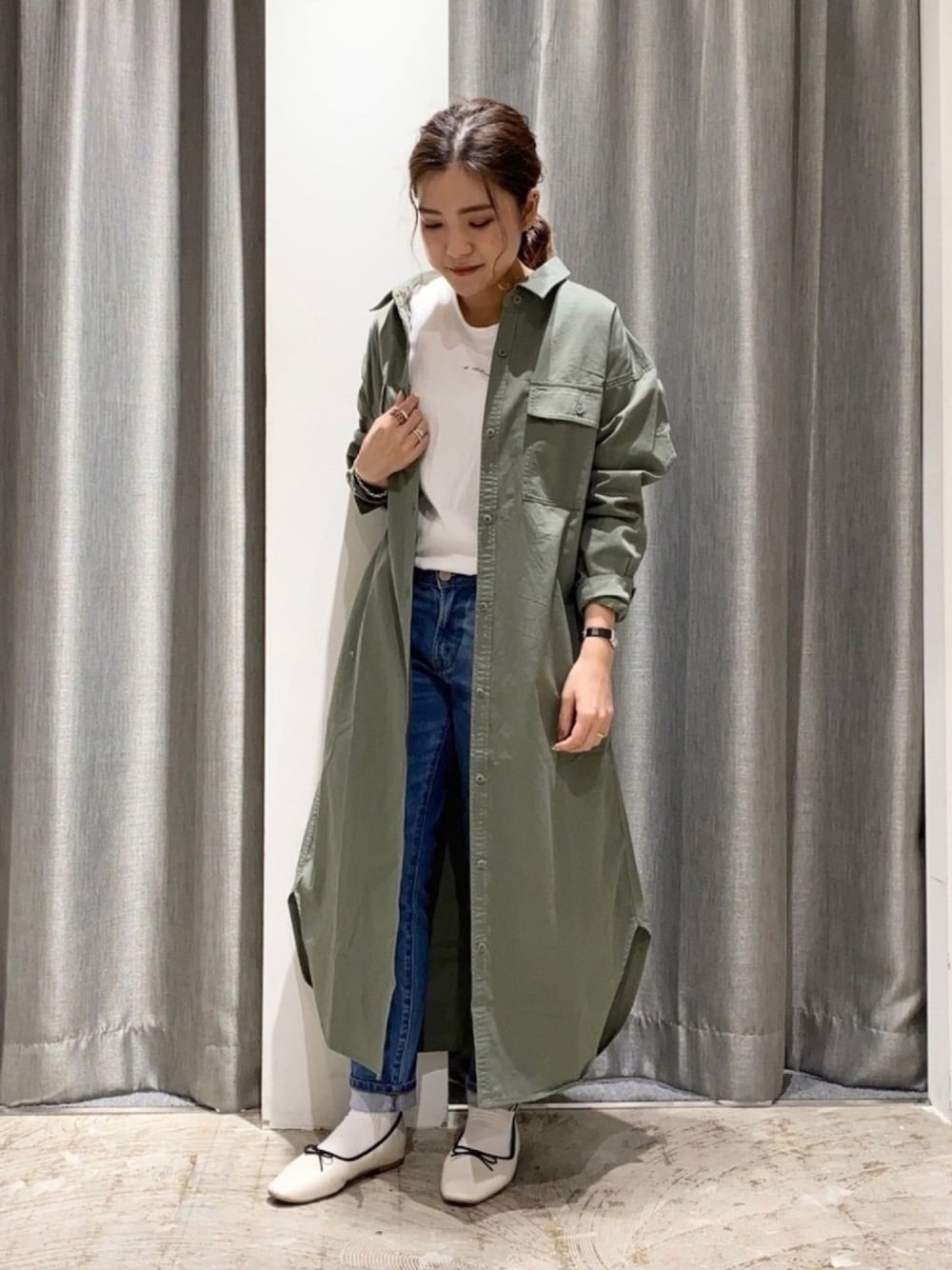 グリーン系のワンピース、ホワイト系のTシャツ/カットソー、ブルー系のデニムパンツを着用したレディースの春コーディネートの1枚目の写真