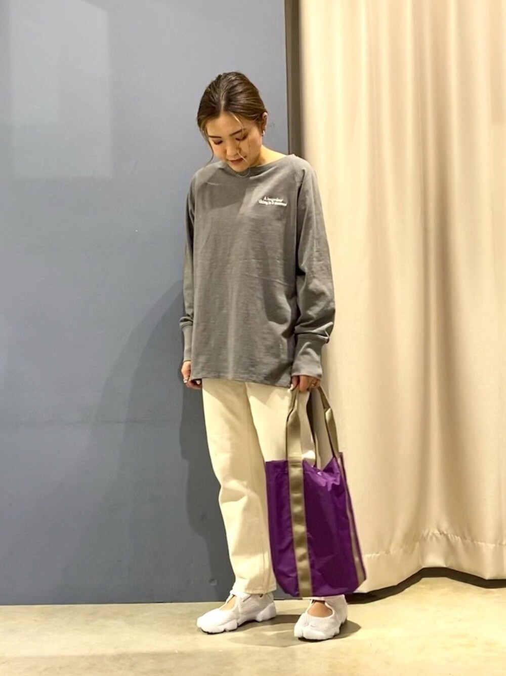 ホワイト系のパンツ、パープル系のトートバッグ、ホワイト系のサンダルを着用したレディースの春コーディネートの1枚目の写真