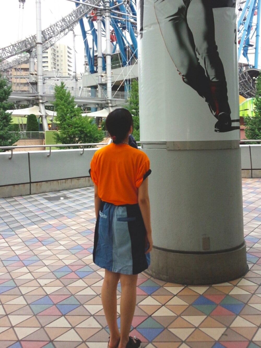 ブラック系のサンダル、ブラック系のTシャツ/カットソー、ブルー系のデニムスカートを着用したレディースの冬コーディネートの1枚目の写真