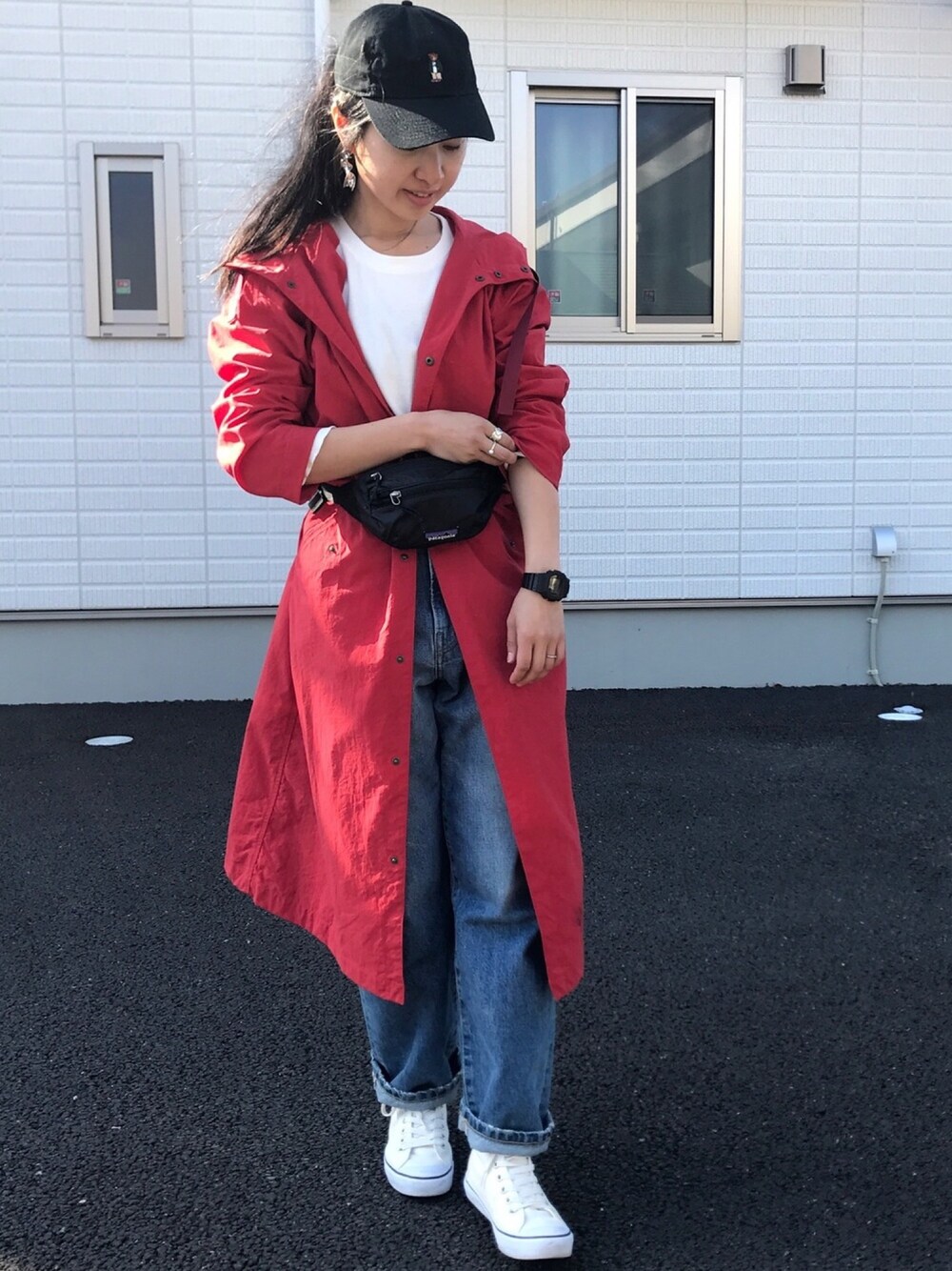 レッド系のモッズコート、ブルー系のデニムパンツ、ホワイト系のスニーカーを着用したレディースの春コーディネートの1枚目の写真