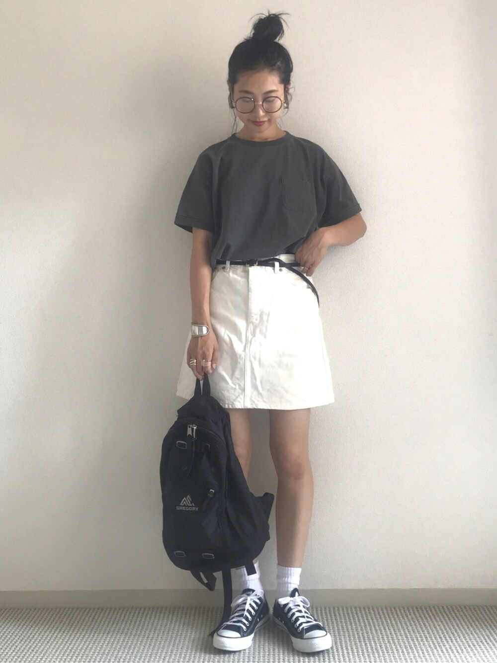 グレー系のTシャツ/カットソー、ブラック系のバックパック/リュック、ブラック系のスニーカーを着用したレディースの夏コーディネートの1枚目の写真