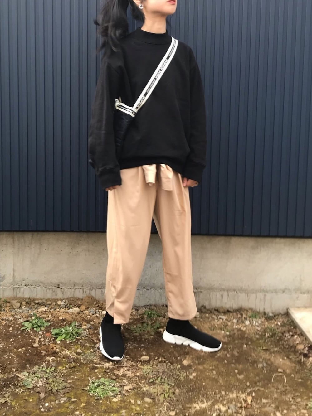 ベージュ系のワンピース、ブラック系のパーカー、ブラック系のブーツを着用したレディースの冬コーディネートの1枚目の写真