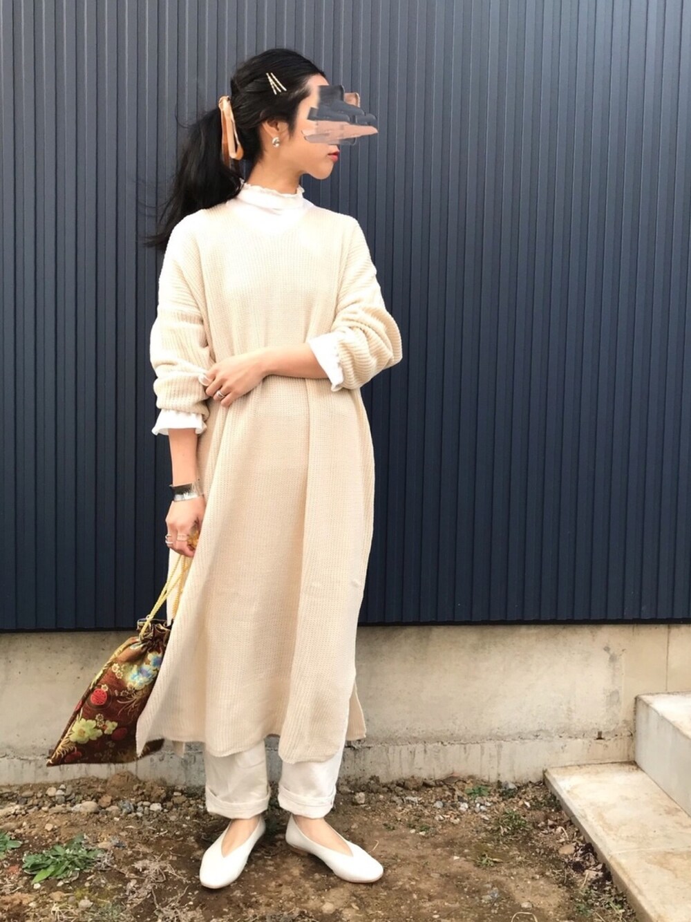 ホワイト系のワンピース、ホワイト系のデニムパンツ、ホワイト系のパンプスを着用したレディースの冬コーディネートの1枚目の写真