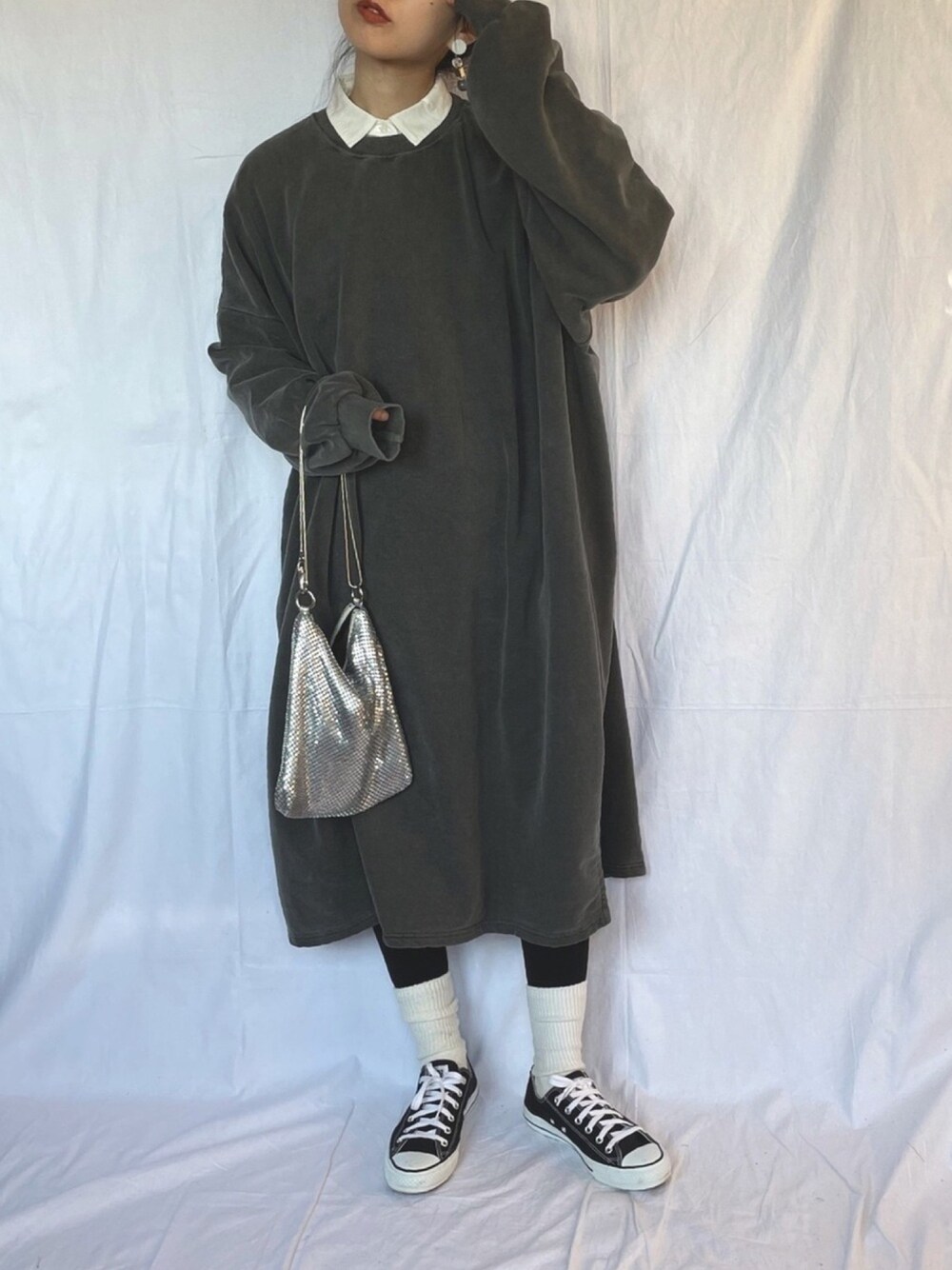 ブラック系のワンピース、ブラック系のスニーカー、シルバー系のショルダーバッグを着用したレディースの冬コーディネートの1枚目の写真