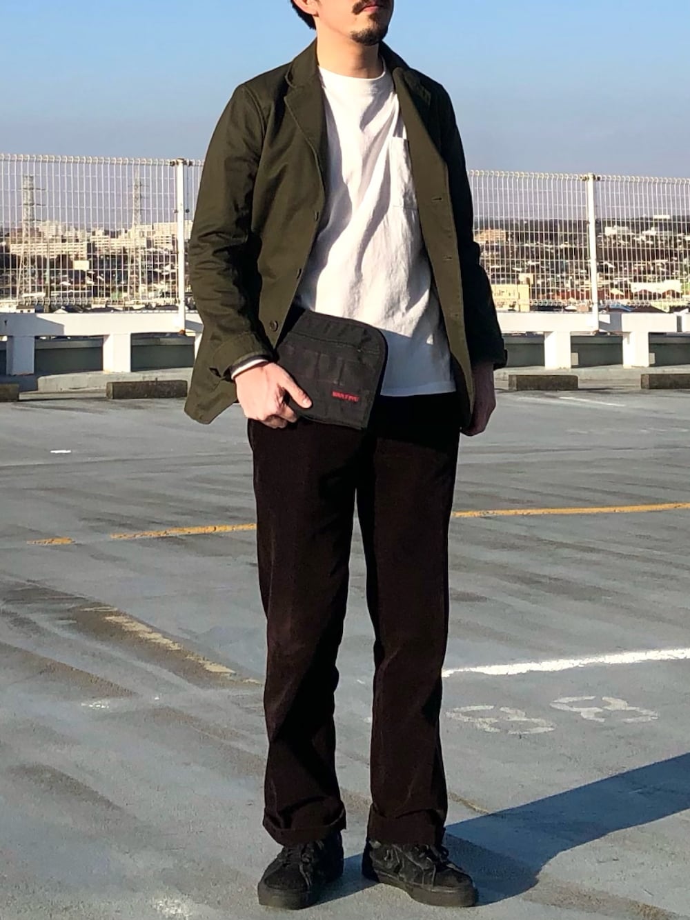 ブラック系のクラッチバッグを着用したメンズの冬コーディネートの1枚目の写真