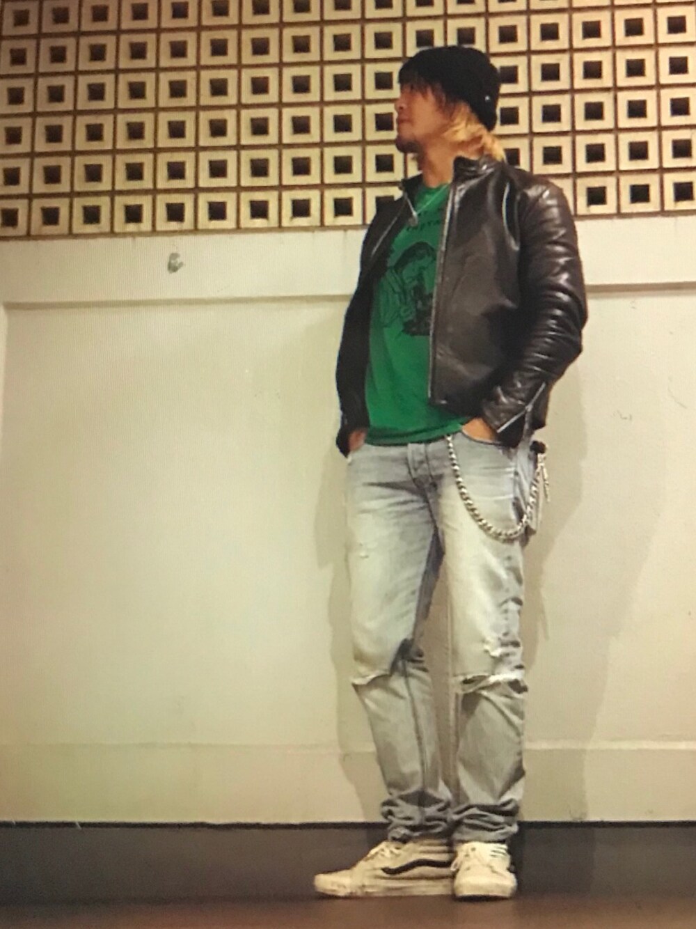 ブラック系のライダースジャケット、グリーン系のTシャツ/カットソー、ブルー系のデニムパンツを着用したメンズの秋コーディネートの1枚目の写真