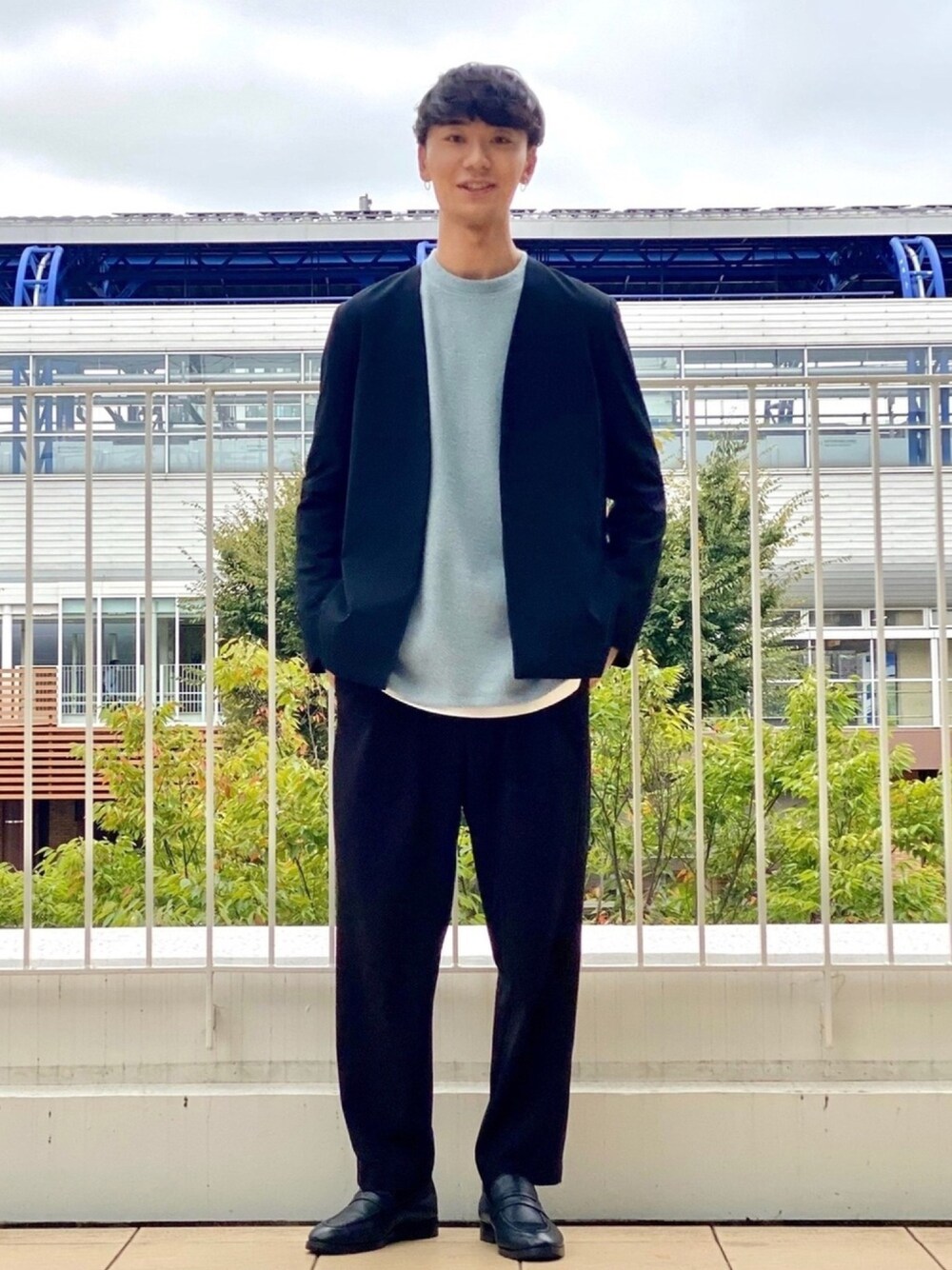 ブラック系のノーカラーコート、ブルー系のスウェット、ブラック系のローファーを着用したメンズの秋コーディネートの1枚目の写真