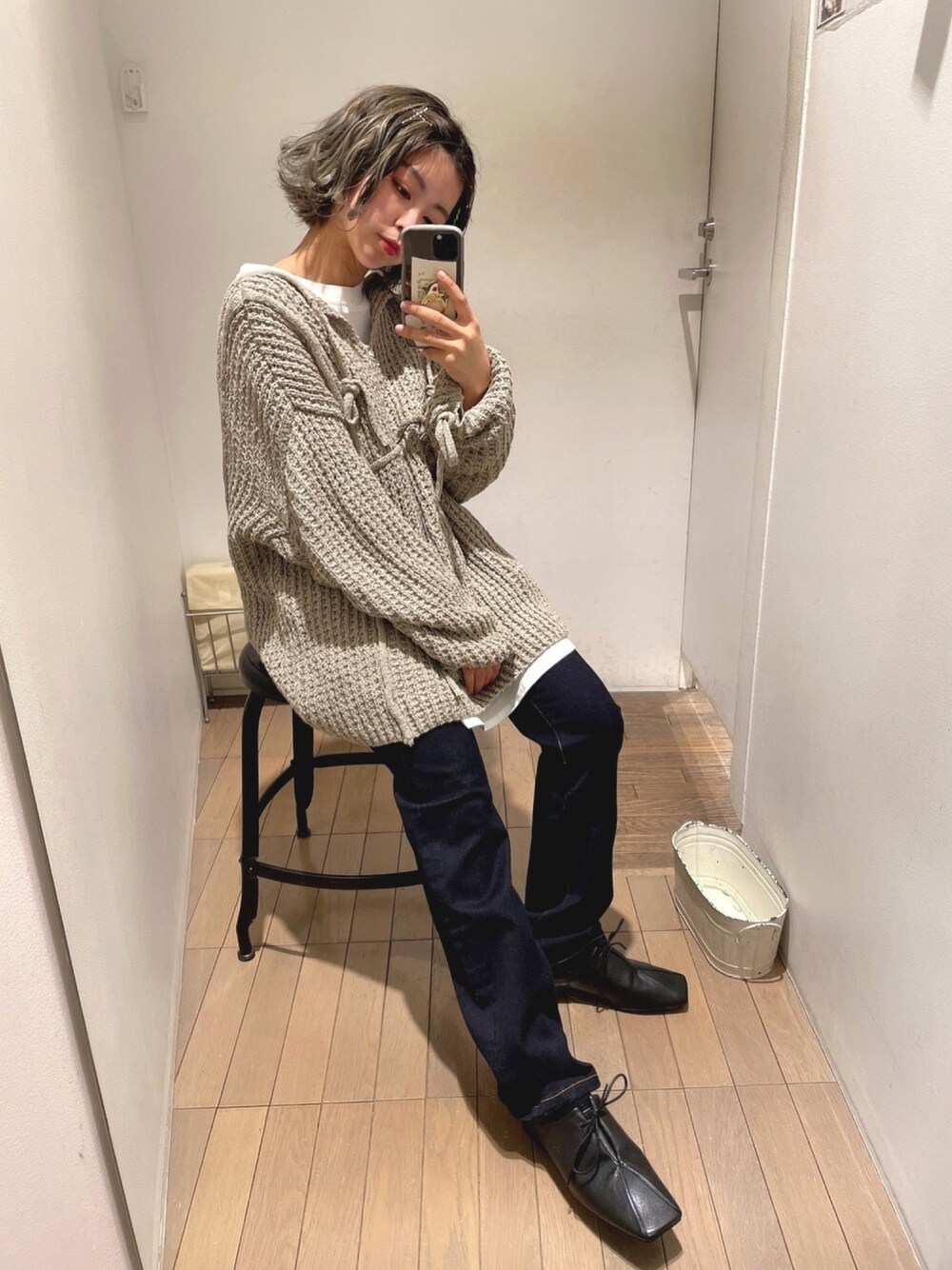 ホワイト系のTシャツ/カットソー、ベージュ系のニット/セーター、ブルー系のデニムパンツを着用したレディースの冬コーディネートの1枚目の写真