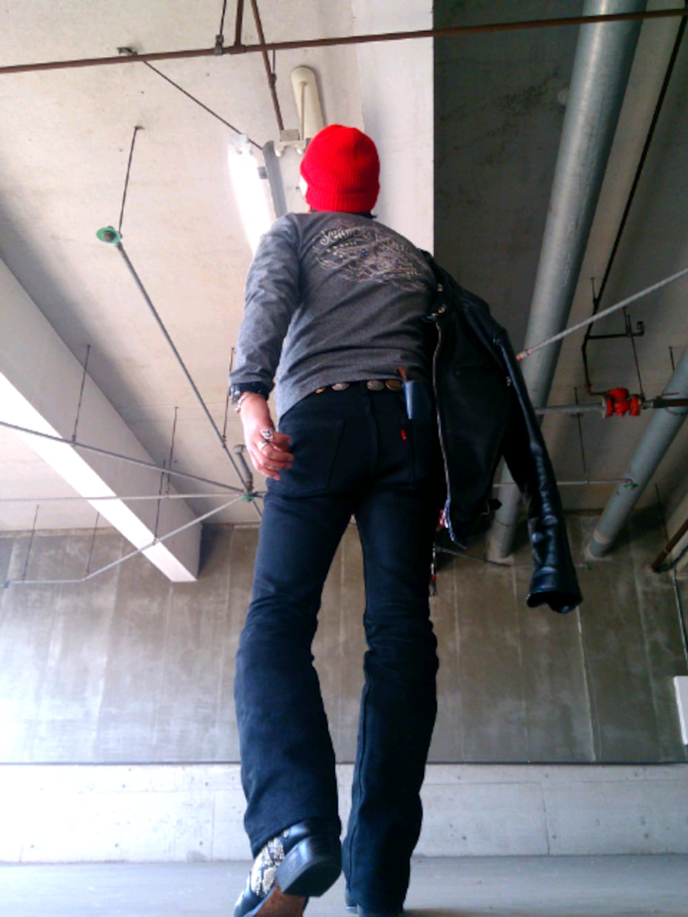 グレー系のTシャツ/カットソー、ブラック系のライダースジャケット、ブラック系のデニムパンツを着用したメンズの春コーディネートの1枚目の写真