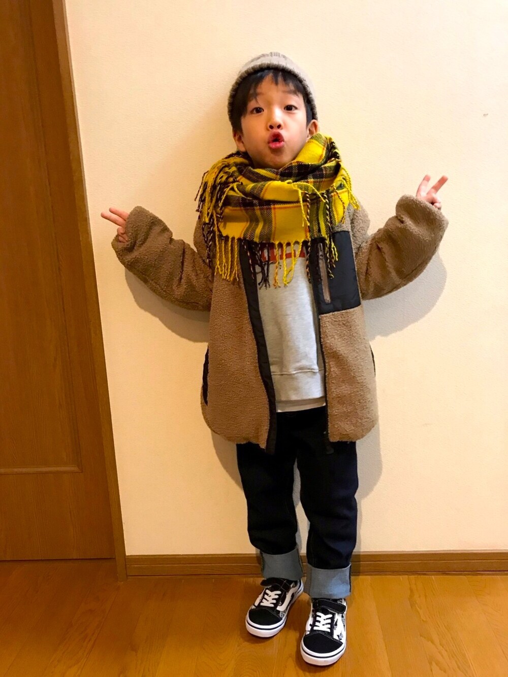 グレー系のスウェット、ブラウン系のブルゾン、ブルー系のデニムパンツを着用したキッズの秋コーディネートの1枚目の写真