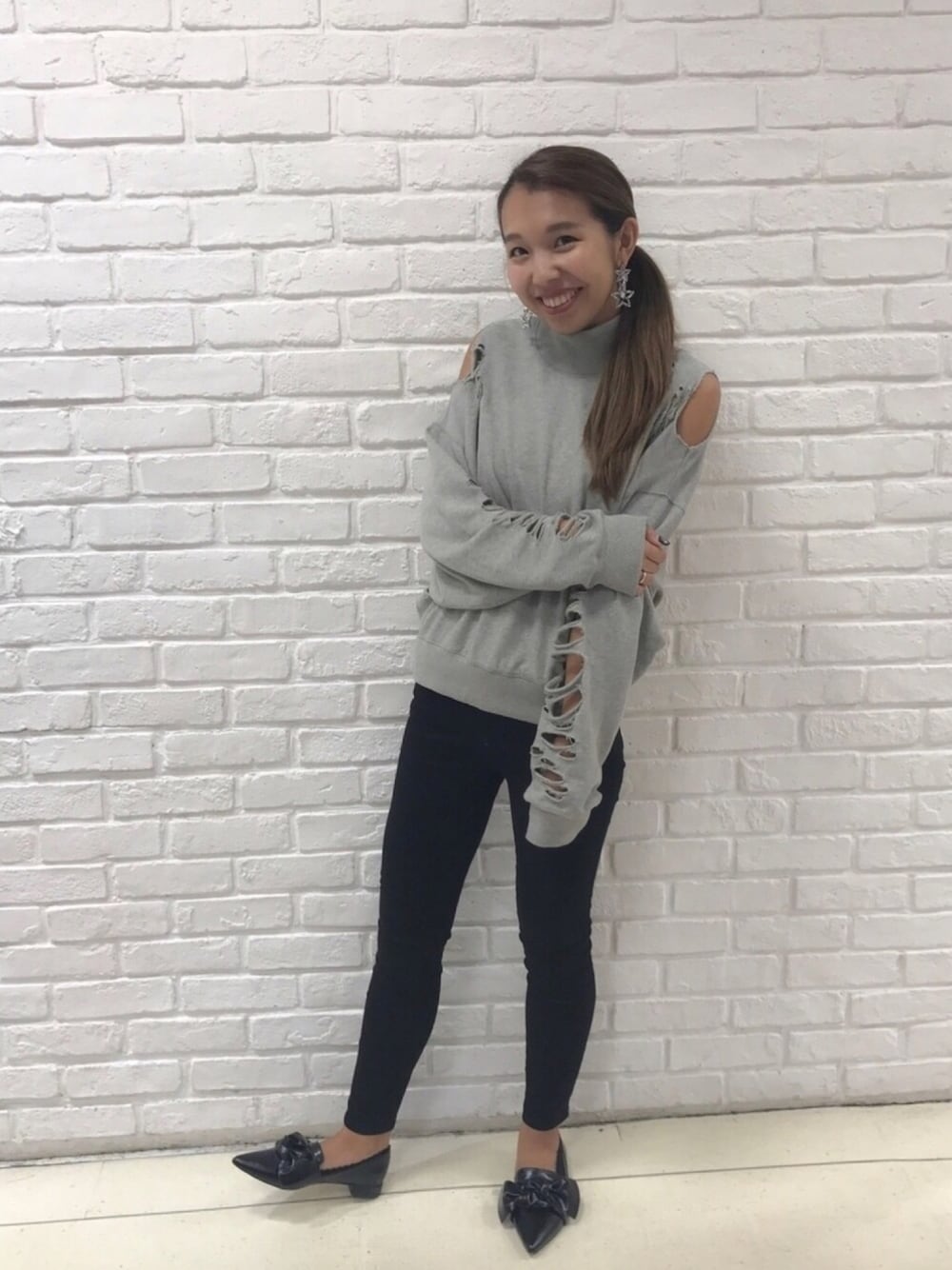 グレー系のスウェット、ブラック系のデニムパンツ、ブラック系のハンドケア/ハンドクリームを着用したレディースの秋コーディネートの1枚目の写真