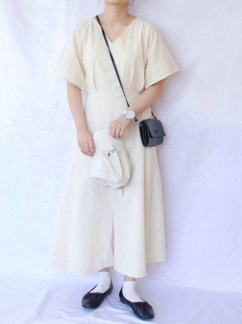 ベージュ系のワンピース/ドレス、ブラック系のバレエシューズ、ホワイト系のキャップを着用したレディースの夏コーディネートの1枚目の写真