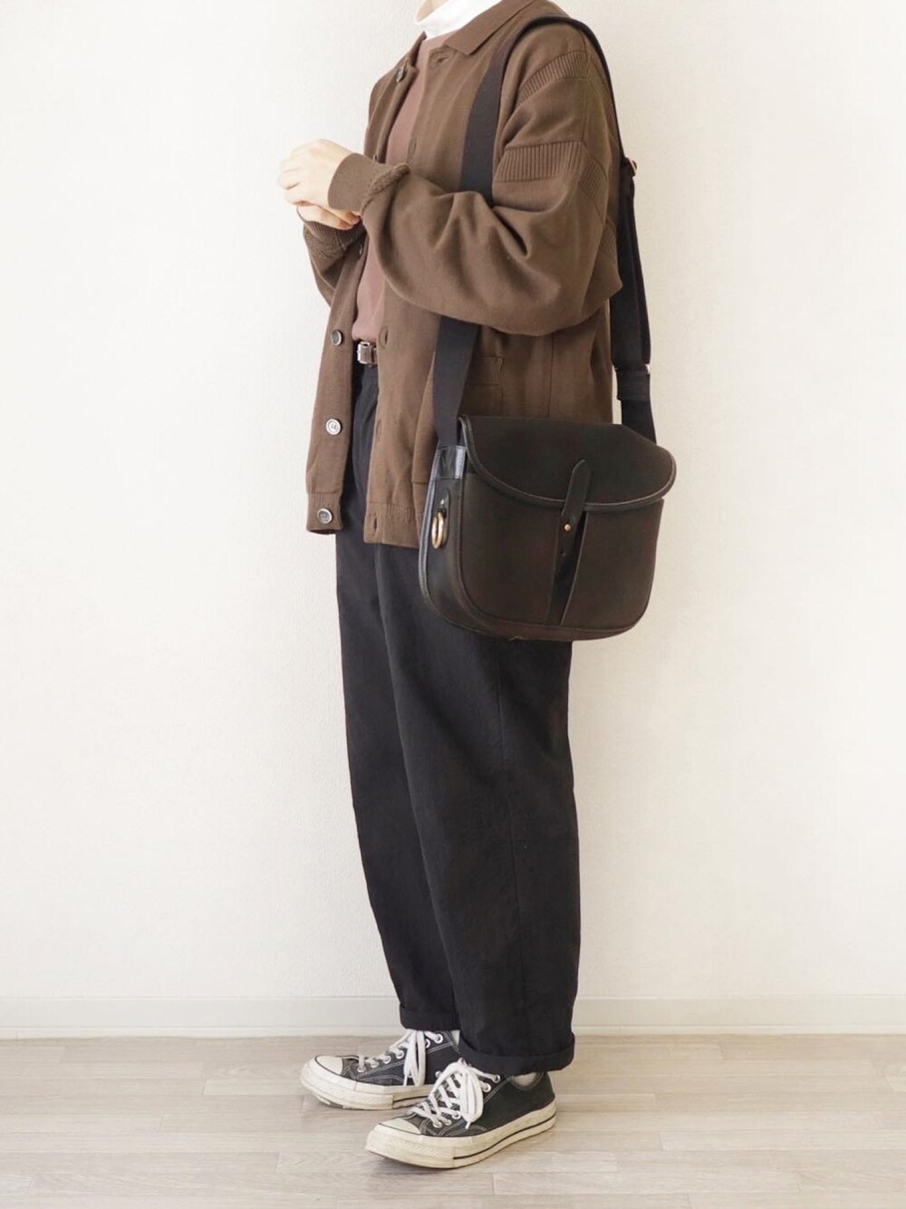 ブラウン系のカーディガン/ボレロ、ブラウン系のTシャツ/カットソー、ブラック系のショルダーバッグを着用したメンズの春コーディネートの1枚目の写真