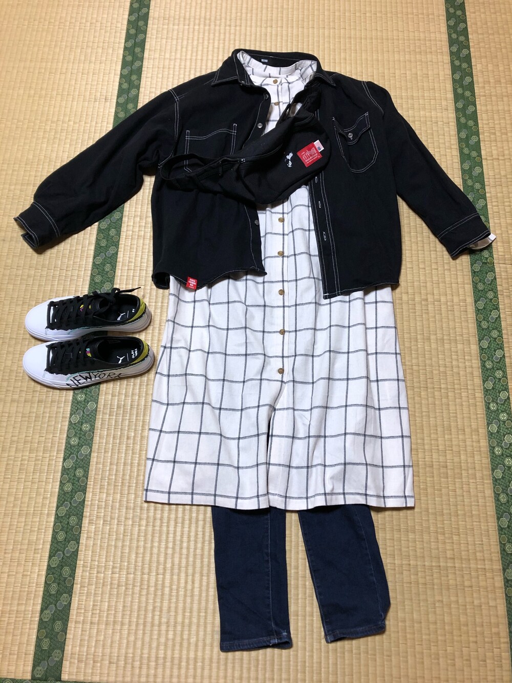 ホワイト系のワンピース、ブルー系のデニムパンツ、ホワイト系のスニーカーを着用したレディースの冬コーディネートの1枚目の写真