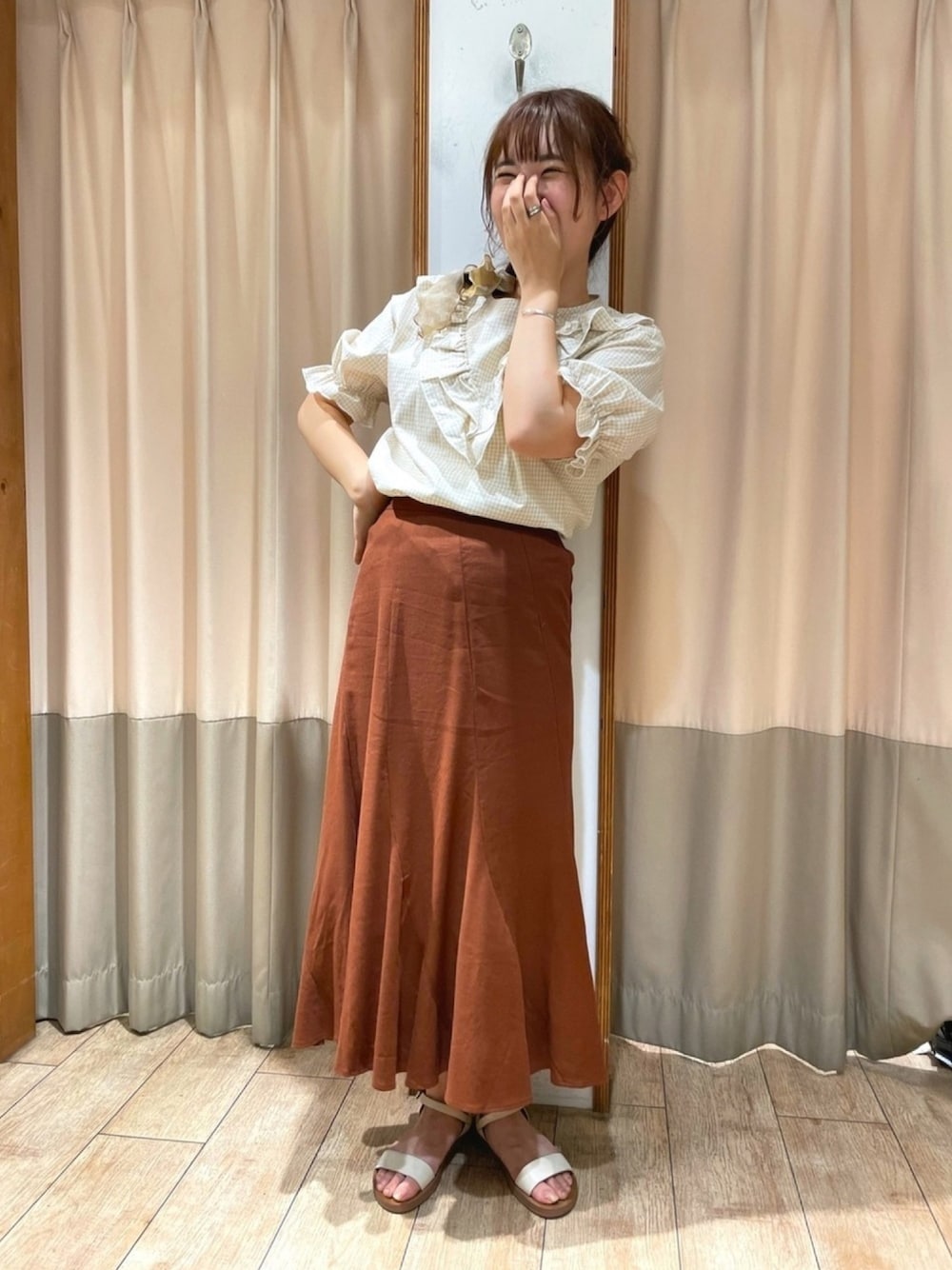 ベージュ系のシャツ/ブラウス、ブラウン系のスカートを着用したレディースの春コーディネートの1枚目の写真