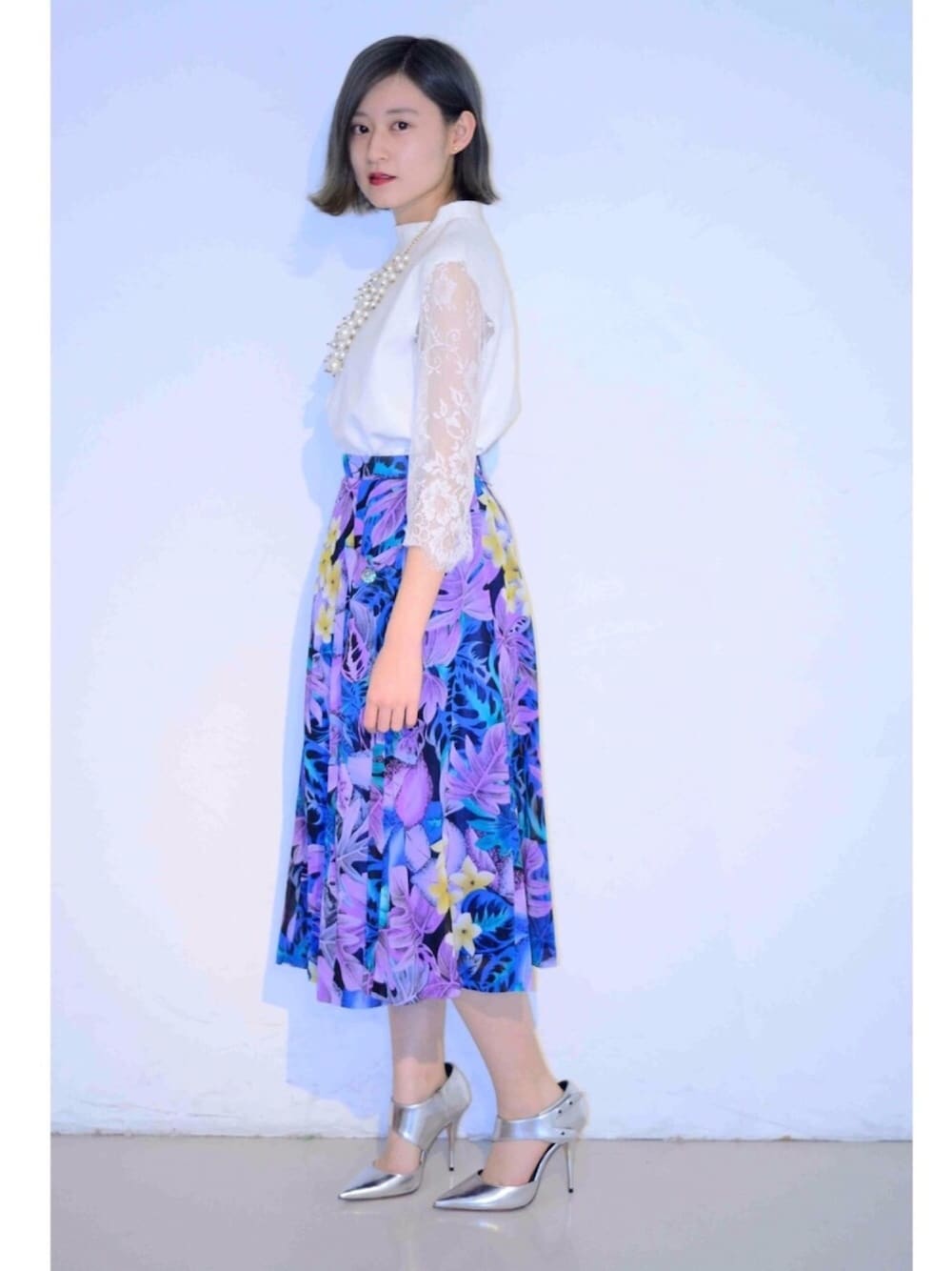 パープル系のスカートを着用したレディースの春コーディネートの1枚目の写真