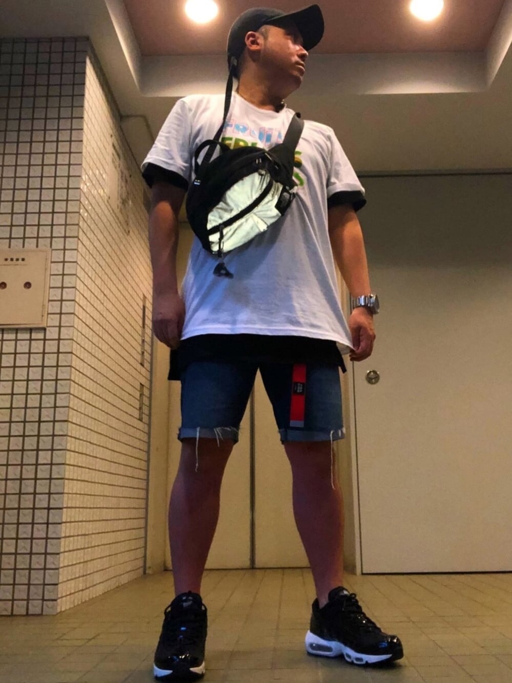 ホワイト系のTシャツ/カットソー、シルバー系のボディバッグ/ウエストポーチ、ブルー系のデニムパンツを着用したメンズの夏コーディネートの1枚目の写真