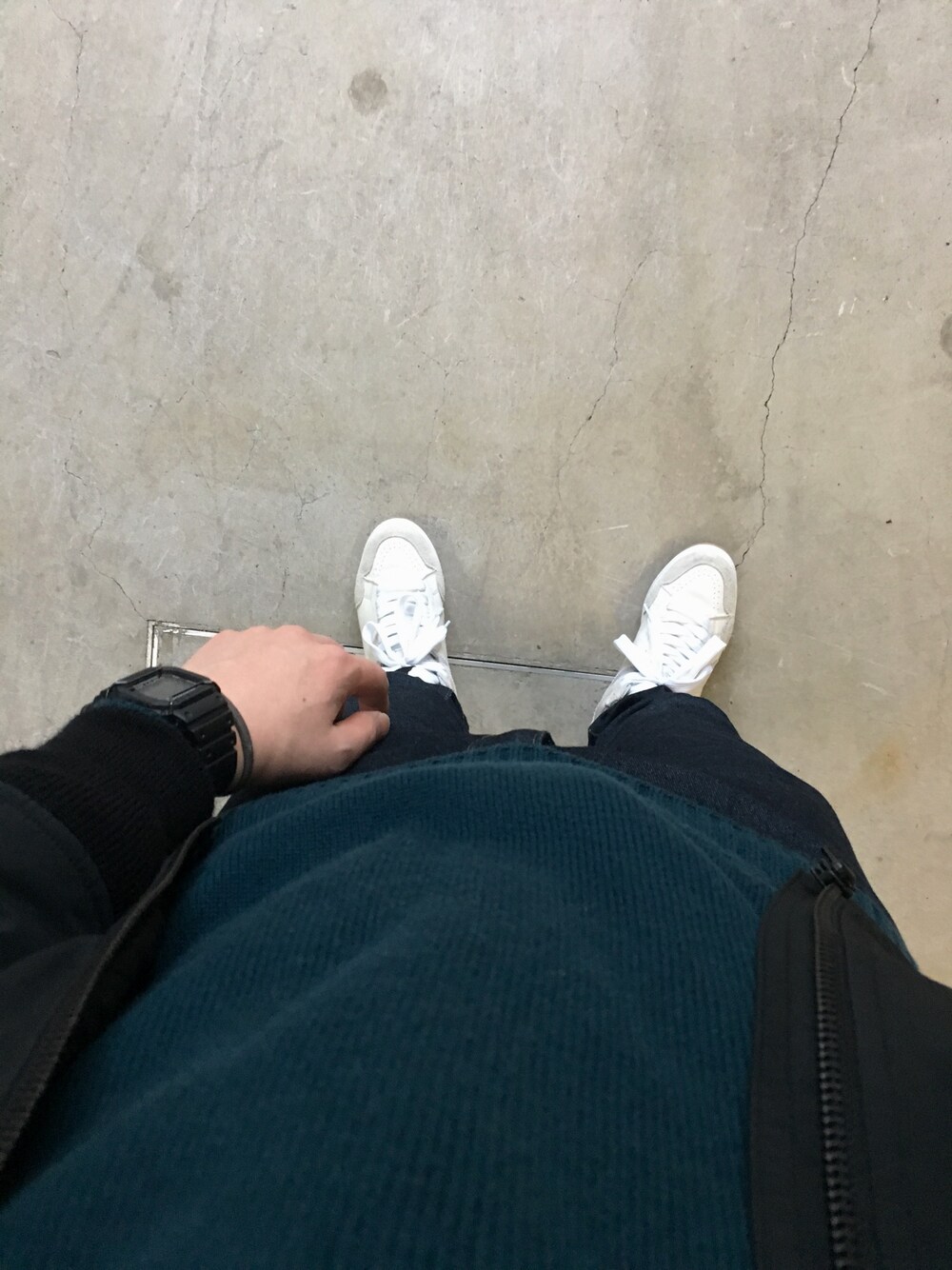 ホワイト系のスニーカー、ブラック系のミリタリージャケット、ブルー系のニット/セーターを着用したメンズの冬コーディネートの1枚目の写真