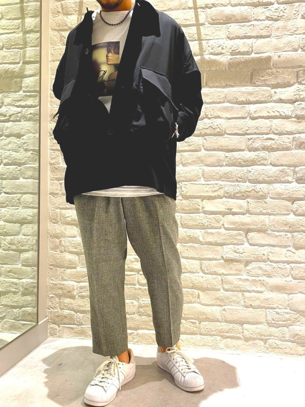 ブラック系のブルゾン、ホワイト系のTシャツ/カットソー、グレー系のその他パンツを着用したメンズの秋コーディネートの1枚目の写真