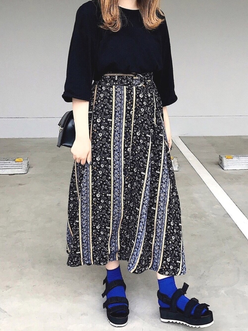 ブラック系のTシャツ/カットソー、ブラック系のスカート、ブラック系のサンダルを着用したレディースの夏コーディネートの1枚目の写真