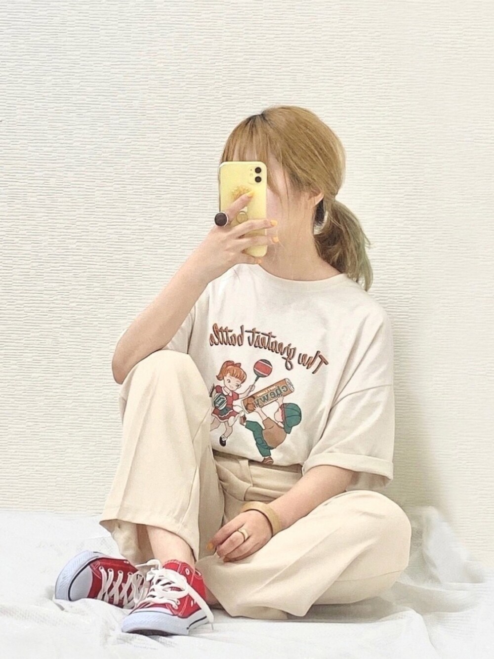 ベージュ系のスラックス、レッド系のスニーカー、ベージュ系のTシャツ/カットソーを着用したレディースの夏コーディネートの1枚目の写真