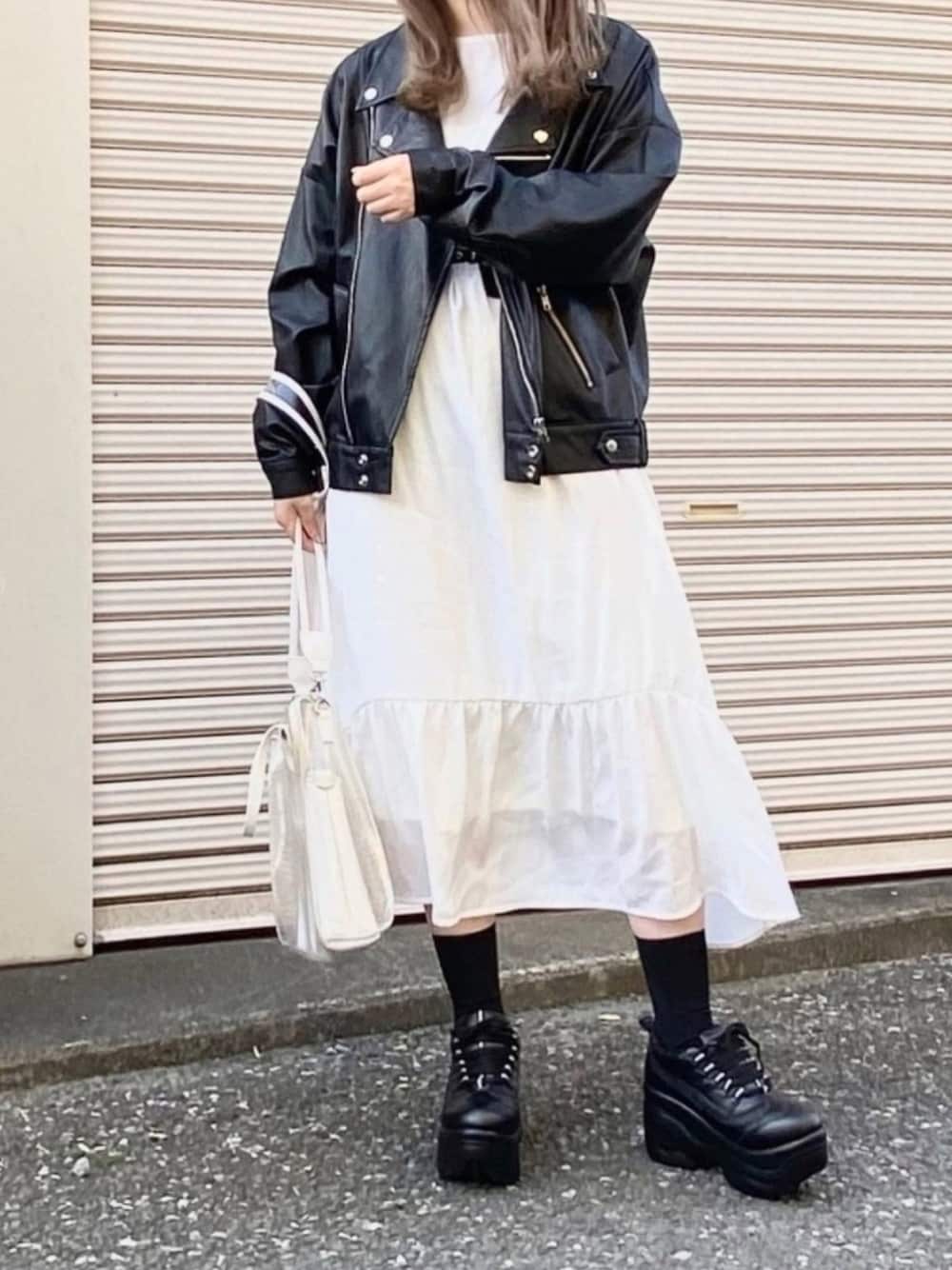 その他のトートバッグ、ブラック系のスニーカー、ブラック系のライダースジャケットを着用したレディースの春コーディネートの1枚目の写真