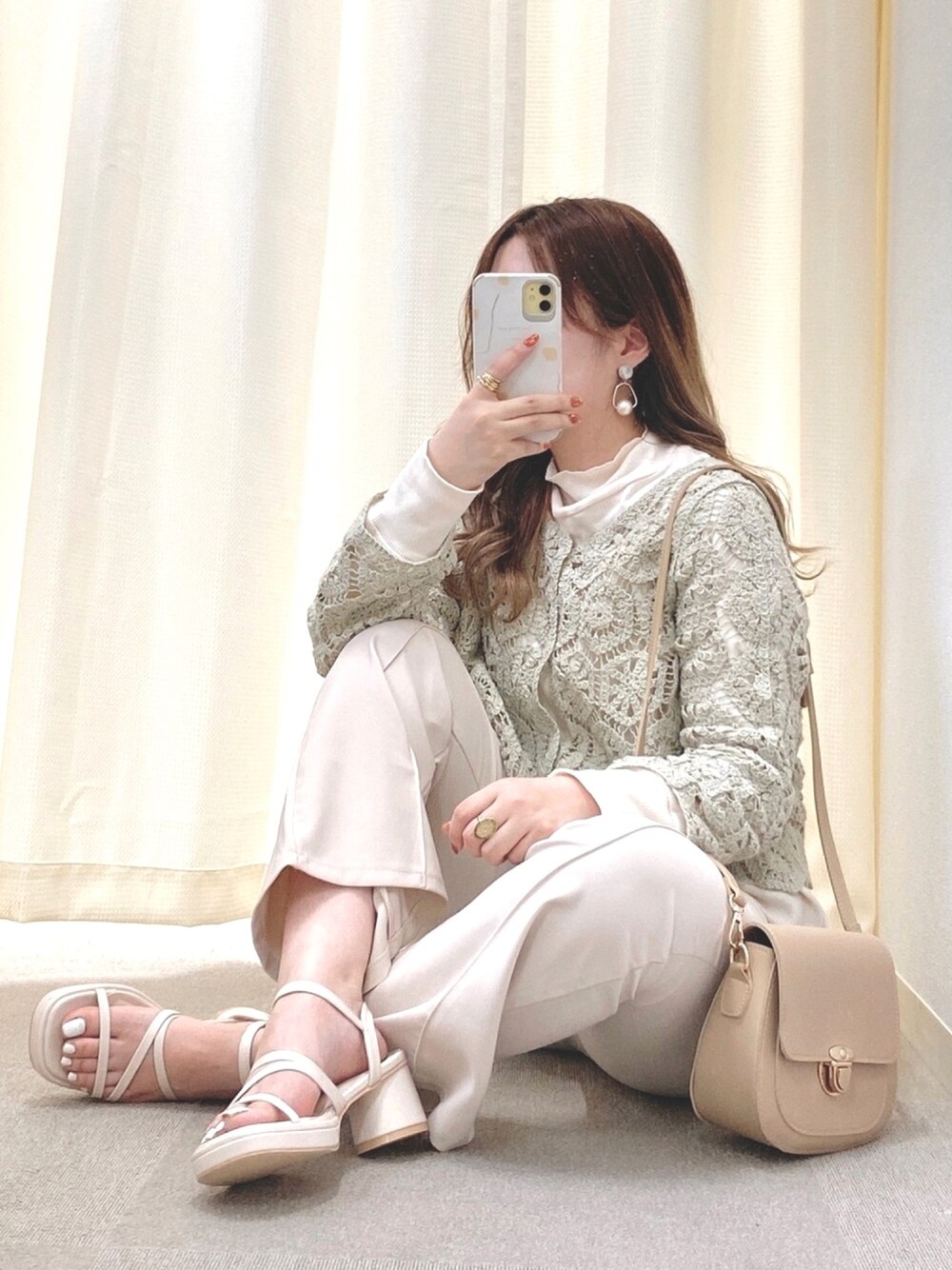 グリーン系のカーディガン/ボレロ、ベージュ系のTシャツ/カットソー、ホワイト系のサンダルを着用したレディースの春コーディネートの1枚目の写真