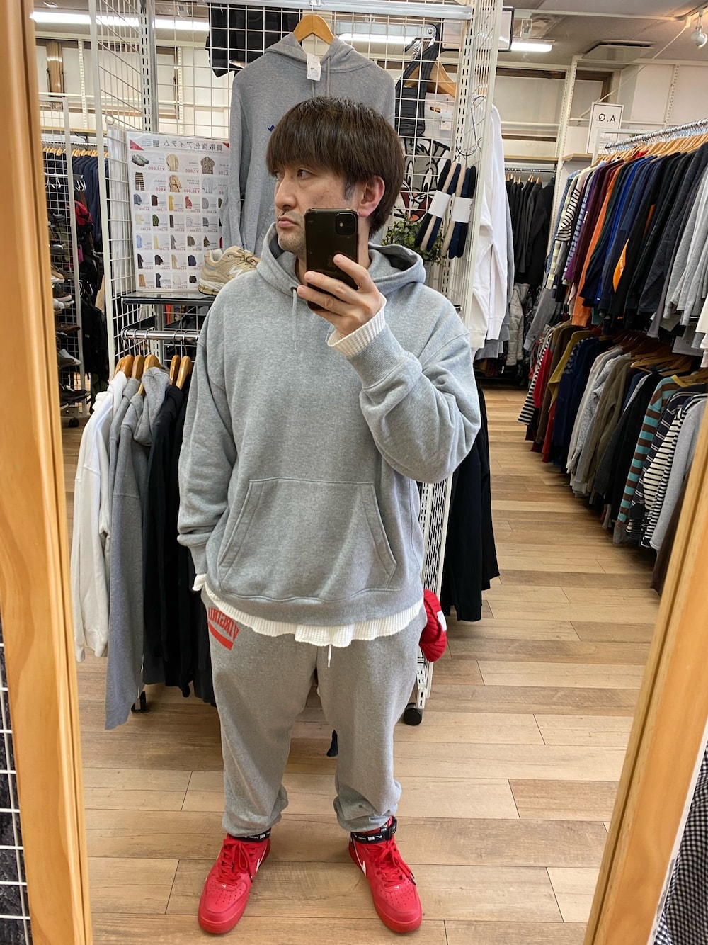 グレー系のパーカー、グレー系のスウェットパンツ、レッド系のスニーカーを着用したメンズの秋コーディネートの1枚目の写真