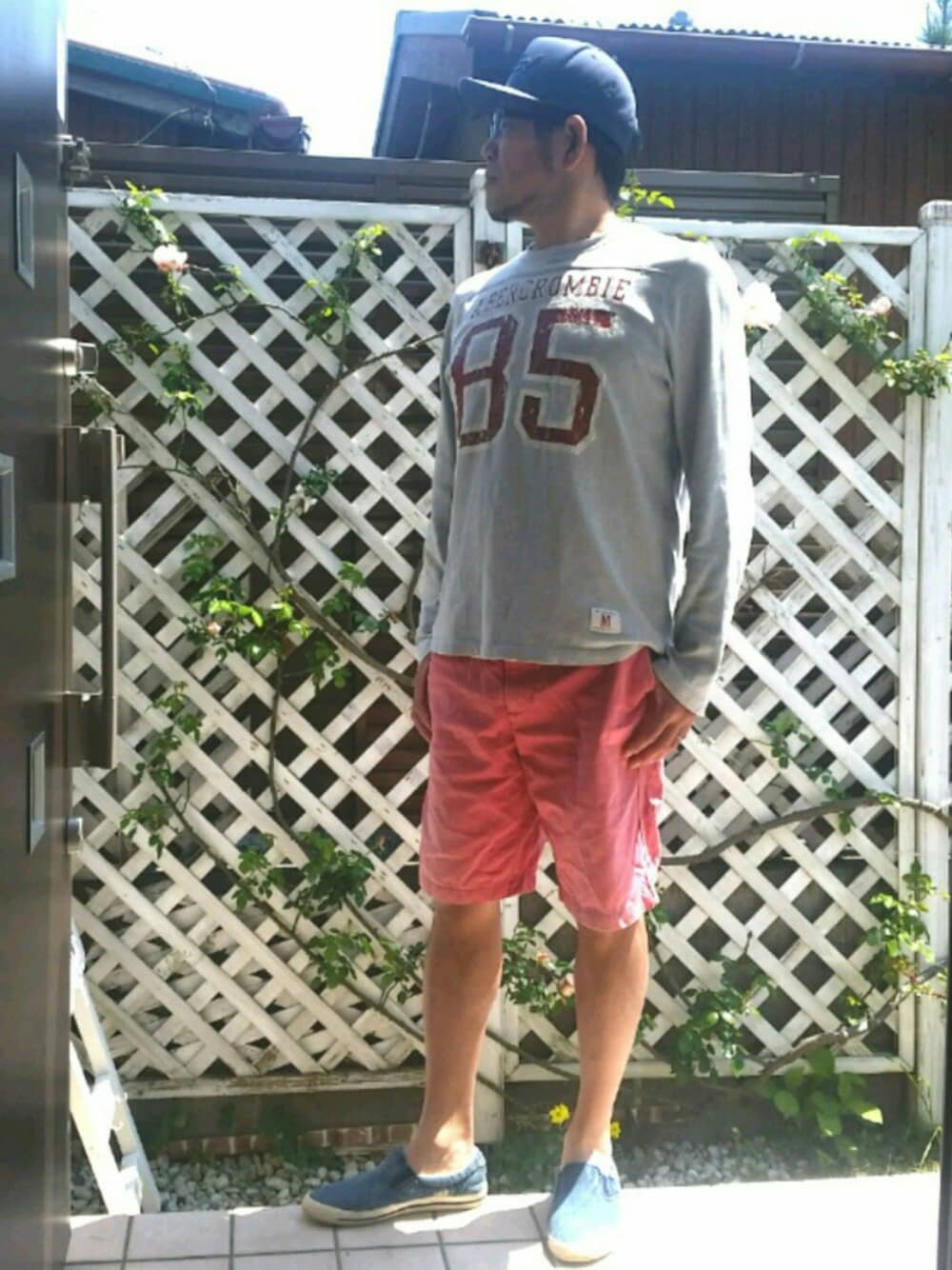 グレー系のTシャツ/カットソー、レッド系のその他パンツ、ブルー系のスリッポンを着用したメンズの春コーディネートの1枚目の写真