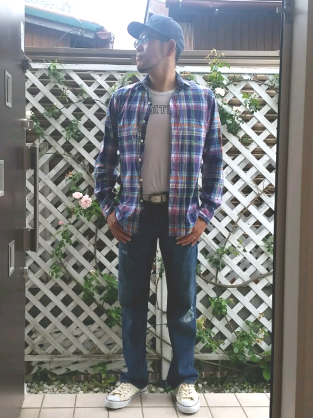 ブルー系のデニムパンツ、ホワイト系のスニーカー、ホワイト系のTシャツ/カットソーを着用したメンズの春コーディネートの1枚目の写真