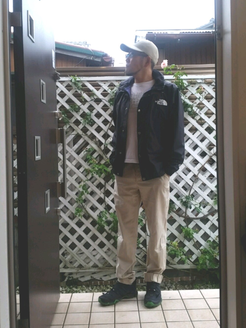 ブラック系のマウンテンパーカー、ベージュ系のチノパンツ、ホワイト系のTシャツ/カットソーを着用したメンズの夏コーディネートの1枚目の写真